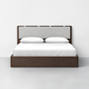 A modern bed with a dark wooden frame, a light gray upholstered headboard, and white bedding with two pillows, set against a plain white wall and light gray floor.