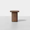 A modern wooden side table with a rectangular top and a thick, solid central pedestal base, set against a plain white background.