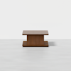 A modern rectangular wooden coffee table with a thick, solid base, set against a plain white background.