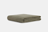 A neatly folded, olive green quilt or blanket is shown against a plain white background.