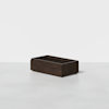 A rectangular, dark brown wooden storage box sits on a light gray surface against a plain white background. The box has clean lines and no visible handles or decorations.