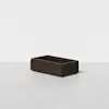 A rectangular, dark brown wooden storage box sits on a light gray surface against a plain white background. The box has clean lines and no visible handles or decorations.