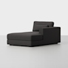 A modern dark gray chaise lounge with a right armrest and a low backrest, set against a plain light gray background. The design is minimalist and contemporary.