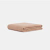 A neatly folded, light brown blanket is placed on a plain white background.