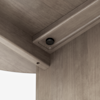 Close-up view of the corner and underside of a wooden table or desk, showing the wood grain, assembly hardware, and a round cam lock fitting used for securing the structure.