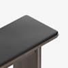 A close-up view of a bench with a dark gray fabric cushion on top of a wooden base, shown against a plain white background.