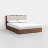 A modern wooden bed with a light beige upholstered headboard, white bedding, and two pillows, set against a plain white background.