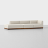 A modern beige sectional sofa with low backs and arms, featuring a wooden base, set against a plain light gray background.