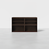 A dark brown wooden bookshelf with four open square compartments, standing on a light gray floor against a plain white background.