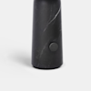 A tall, cylindrical, matte black object with a subtle marbled pattern and a round button near the base, set against a plain white background.