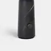 A tall, cylindrical, matte black object with a subtle marbled pattern and a round button near the base, set against a plain white background.