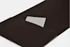 A small gray notebook partially tucked into the front pocket of a dark brown leather sleeve or case, set against a white background.