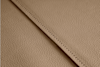 Close-up of beige textured leather with a visible seam running diagonally across the image, showing fine grain and neat stitching.