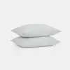 Two plain white pillows are stacked neatly on top of each other against a clean, white background.
