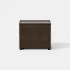 A modern, dark wood nightstand with two drawers, set against a plain white background and floor.