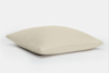 A plain, square, beige pillow with a soft texture is shown lying flat on a white background.