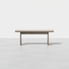 A simple, modern wooden bench with clean lines and a light gray finish, set against a plain white background.