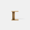 A minimalist wooden side table with an I-shaped design, featuring flat rectangular surfaces on top and bottom, and a vertical central support, set against a plain white background.