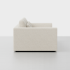 A side view of a modern, light beige upholstered sofa with two back cushions, set against a plain white background.