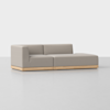 A modern, light gray sectional sofa with a low backrest and wide right-side chaise lounge, set on a light wooden base, positioned on a smooth, light-colored floor against a plain white background.