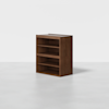 A wooden shelving unit with three open shelves and a flat top, positioned on a plain light gray floor against a white background.