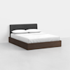 A modern bed with a dark wood platform base, a dark gray upholstered headboard, and white bedding with two white pillows, set in a minimalist room with white walls and floor.