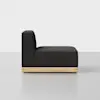 A modern armless black upholstered chair with a tall back and thick seat cushion, featuring a light wooden base, viewed from the side against a plain white background.