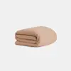 A neatly folded, light brown blanket on a plain white background.