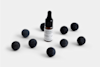 A small dropper bottle labeled DEEP FOREST is surrounded by nine round, dark, textured balls on a plain white background.