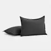 Two dark gray rectangular pillows with a simple, plain design are positioned on a white background; one pillow stands upright while the other lies flat behind it.