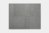 A square gray carpet tile with a subtle pattern of four rectangles, each showing a slightly different texture and shade of gray, set against a plain light background.