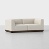 A modern, L-shaped cream-colored sofa with clean lines, plush cushions, and a dark wooden base, set against a plain white background.