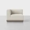 A modern, light beige upholstered corner sofa seat with a wooden base, pictured against a plain, light gray background. The design is minimalist and contemporary.