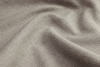 Close-up of light beige fabric with a textured, woven surface, showing soft folds and natural creases.