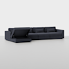A dark gray sectional sofa with three seats, an extended chaise on the left side, and a lift-up storage compartment under the chaise, set in a plain, light-colored room.