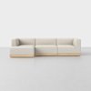 A modern, light beige sectional sofa with wooden base, featuring clean lines and a low-profile design, is placed on a smooth, light gray floor against a plain white background.