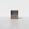 A minimalist, light gray wooden nightstand with two drawers and an open shelf, set against a plain white background.