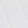 Close-up of a white quilted fabric with a square pattern, showing soft texture and clean stitching lines.