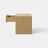 A simple, square wooden box with smooth sides and a flat top, placed on a light gray surface against a plain white background.