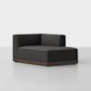 A modern, dark gray sectional sofa with a low back and armrest on the left side, featuring a wooden base, is set against a plain white background.