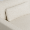 Close-up of a modern cream-colored fabric sofa with a matching rectangular cushion. The upholstery has a subtle textured pattern, and the overall design appears minimalist and comfortable.