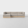 A modern, light gray sectional sofa with clean lines and a low wooden base, set against a plain white background on a smooth, light-colored floor.