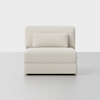 A modern, armless cream-colored loveseat with a rectangular back cushion and a matching cylindrical pillow, placed on a light gray floor against a plain white background.
