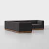 A modern black sectional sofa with clean lines, low backrests, and a wooden base sits on a light gray floor against a plain white background.