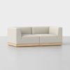 A modern, light beige sectional sofa with clean lines, cushioned seats, and a wooden base, set against a plain white background.