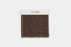 A brown woven fabric swatch with a white label on top displaying the word THUMA in black uppercase letters, set against a plain white background.