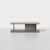 Minimalist rectangular wooden coffee table with a flat top, open side shelf on the left, and closed storage compartment in the center, set against a plain white background.
