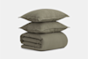 A neatly folded olive green comforter with two matching pillows stacked on top, set against a plain white background.
