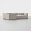 A modern, L-shaped sectional sofa with light beige upholstery and a low wooden base, set on a smooth, light grey floor against a plain white background.