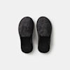 A pair of black, textured, slip-on house slippers shown from above on a plain white background.